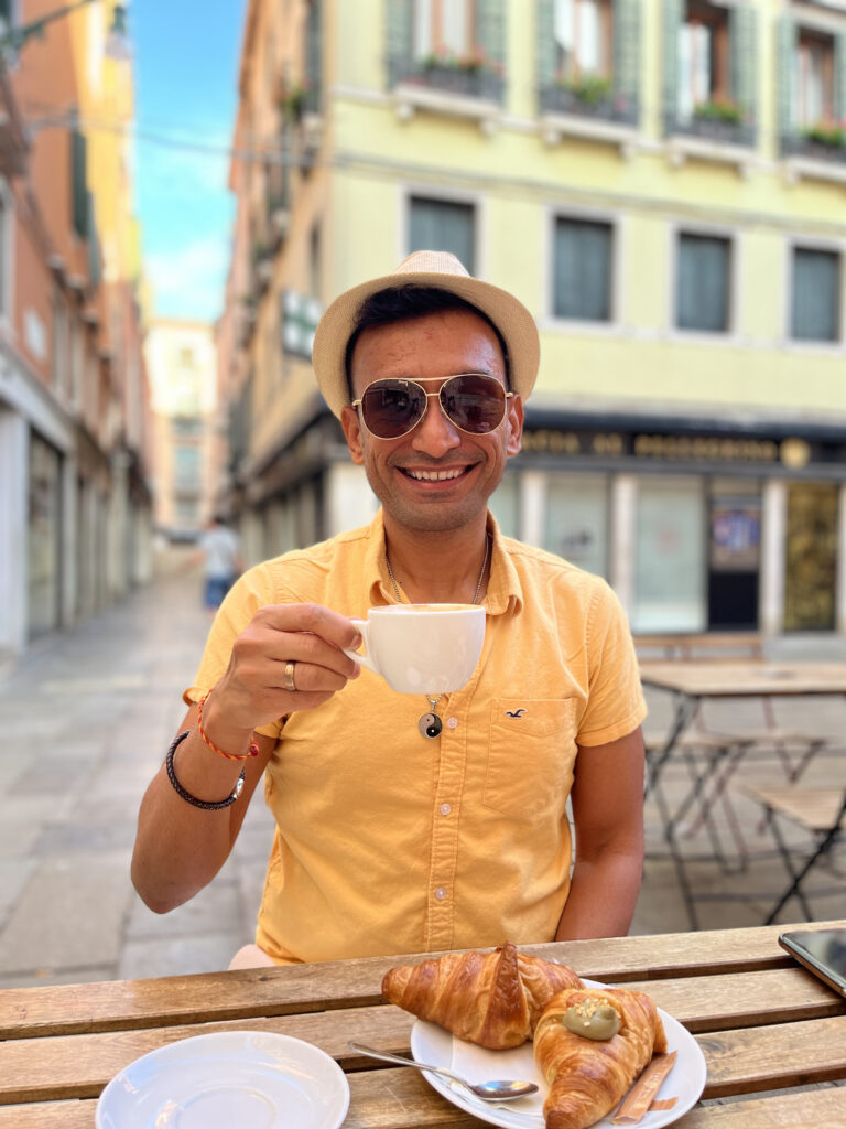 Man enjoying coffee and croissants in Venice, Italy 