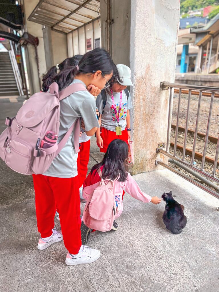 kids play with cats at HuoTong Cat Village, a day trip from Taipei
